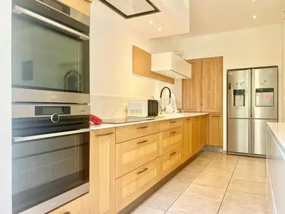 a kitchen with wooden cabinets and stainless steel appliances at Bourgeois House - 16 personnes, Piscine, 6 chambres, 8 lits, 4 SDB, Centre-ville, CLIM in Salon-de-Provence