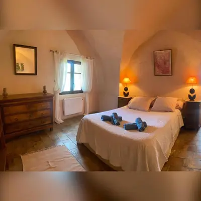 a bedroom with a bed with two blue shoes on it at Bastide de Bénezet in Mérindol