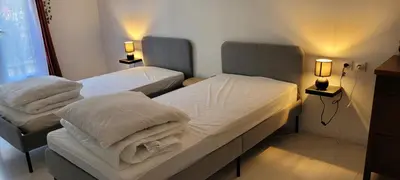 two twin beds in a room with two lamps at Appartement de la Villa Del Sol in Pierrevert