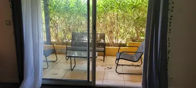 a glass door with two chairs and a table on a patio at Appartement de la Villa Del Sol in Pierrevert