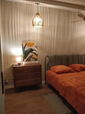 a bedroom with a bed and a nightstand with a lamp at Maison de Charme Rénovée 3 Chbres Hyper Centre Historique in LʼIsle-sur-la-Sorgue
