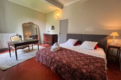 a bedroom with a bed and a table and a mirror at Elivi Elegant Art Deco house with Garden Walk to the Heart of Town in LʼIsle-sur-la-Sorgue