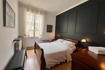 a bedroom with a bed and a desk and a window at Elivi Elegant Art Deco house with Garden Walk to the Heart of Town in LʼIsle-sur-la-Sorgue