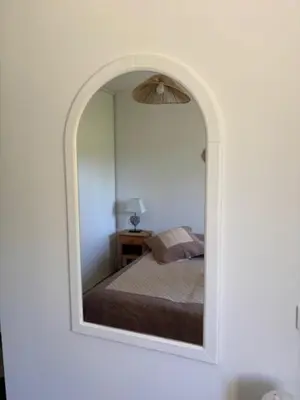 a mirror reflecting a bed in a bedroom at 