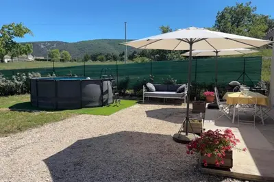 a patio with an umbrella and a hot tub at 