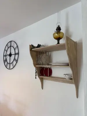a shelf on a wall with a clock on the wall at Maison Tamaris in LʼIsle-sur-la-Sorgue