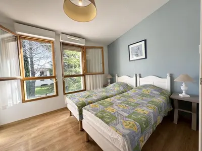 a bedroom with a bed and two windows at résidence avec piscines à proximité de Gordes in Gordes