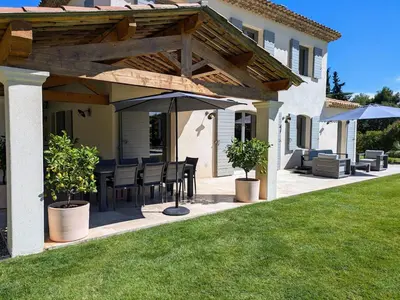 a patio with a table and an umbrella at Villa haut de gamme avec piscine et grand jardin in Aix-en-Provence