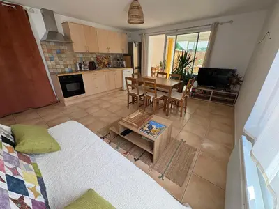 a living room with a kitchen and a dining room at Logement avec jardin et terrain de pétanque privé in Venelles