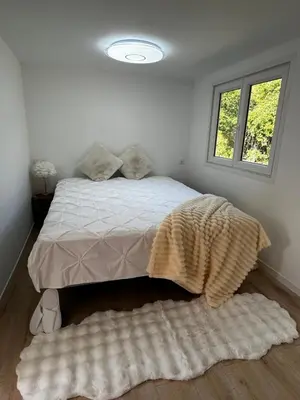 a bedroom with a bed with a blanket and a window at L'Essentiel Room in Velaux
