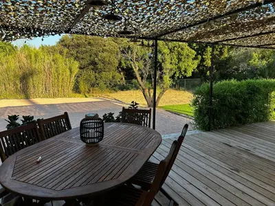 a wooden table and chairs on a wooden deck at L'Essentiel Room in Velaux