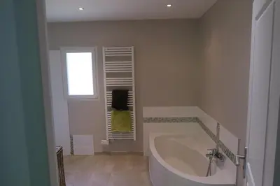 a bathroom with a large tub and a window at L'embellie in Châteaurenard