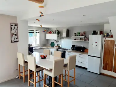 a kitchen with a table and chairs and a white refrigerator at Maison Viens in Viens