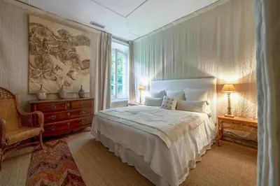 a bedroom with a large bed and a chair at 18Th Century Bastide With Heated Pool In Provence in Apt
