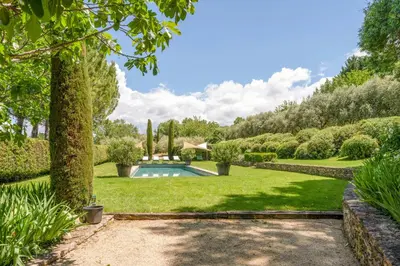 a garden with a swimming pool and trees at 18Th Century Bastide With Heated Pool In Provence in Apt