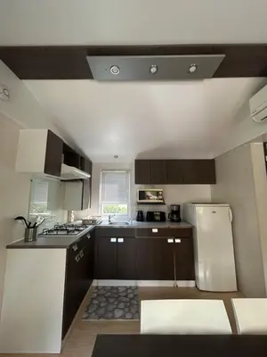 two beds in a small room with a window at mobil home AU SOLEIL in La Roque-dʼAnthéron