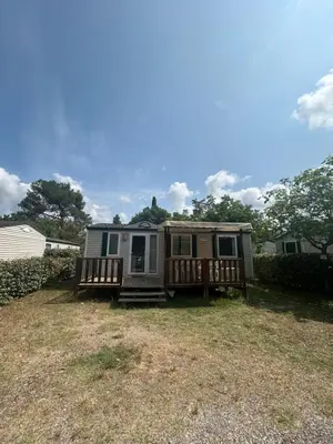 a kitchen with brown cabinets and a white refrigerator at mobil home AU SOLEIL in La Roque-dʼAnthéron