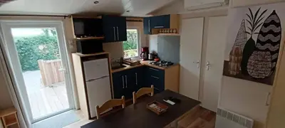 a small kitchen with a table and chairs in it at Mobile Home en Provence in La Roque-dʼAnthéron