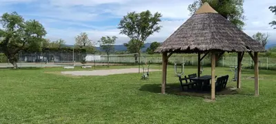 a hut with a table and a bench in a park at Mobile Home en Provence in La Roque-dʼAnthéron