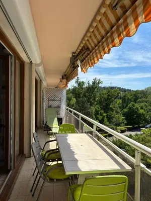 a patio with a table and chairs on a balcony at Aix en Provence, dans grande résidence arborée, appartement de 80m2 in Aix-en-Provence
