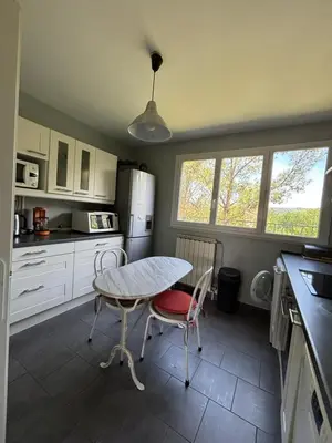 a kitchen with a table and two chairs in it at Aix en Provence, dans grande résidence arborée, appartement de 80m2 in Aix-en-Provence