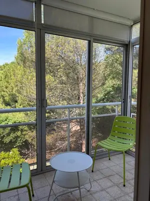 a room with windows and a table and chairs at Aix en Provence, dans grande résidence arborée, appartement de 80m2 in Aix-en-Provence