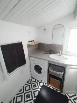 a bathroom with a washing machine and a sink at La Ch'tite Maison in Céreste