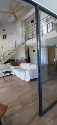 a large room with two beds and a staircase at Villa de charme à Cucuron au pied du luberon in Cucuron