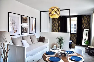 a living room with a white couch and a table at La parenthèse sur la sorgue in LʼIsle-sur-la-Sorgue