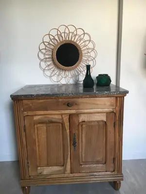 a mirror on top of a wooden cabinet with a table at La parenthèse sur la sorgue in LʼIsle-sur-la-Sorgue