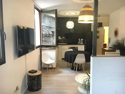 a kitchen and dining room with a table and chairs at La parenthèse sur la sorgue in LʼIsle-sur-la-Sorgue