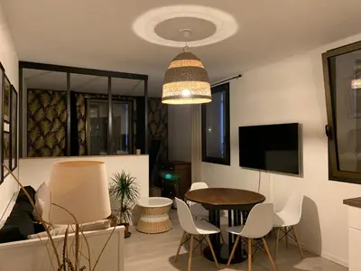 a living room with a table and chairs at La parenthèse sur la sorgue in LʼIsle-sur-la-Sorgue