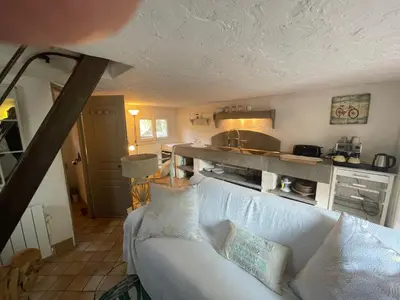 a living room with a white couch and a kitchen at Petite Maison provencale in Lagnes