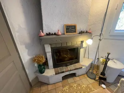 a fireplace in the corner of a living room at Petite Maison provencale in Lagnes