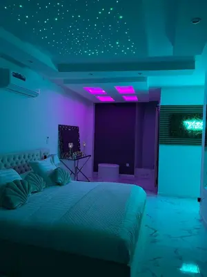 a bedroom with a bed with purple and purple lights at Trésor Étoile, luxe & lumière - Duplex 4 personnes in Pertuis