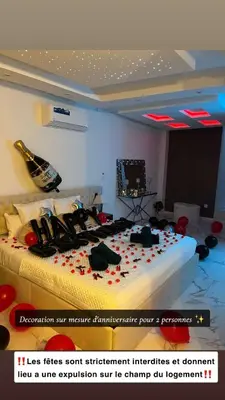 a bedroom with a bed with red flowers on it at Trésor Étoile, luxe & lumière - Duplex 4 personnes in Pertuis