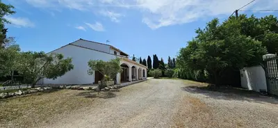 an empty road next to a white house at Villa en Provence avec piscine in Sénas