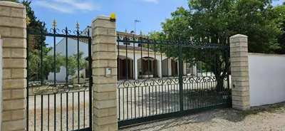 an iron gate in front of a building at Villa en Provence avec piscine in Sénas