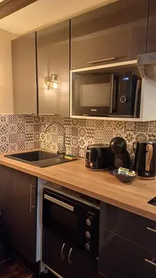 a kitchen with a sink and a microwave at La cachette d'Aix in Aix-en-Provence