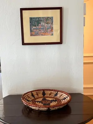a basket on a table with a picture on a wall at Haus PETIT REVE in Oppède in Oppède