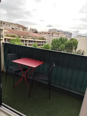 a red table and two chairs on a balcony at Studio plein centre in Aix-en-Provence
