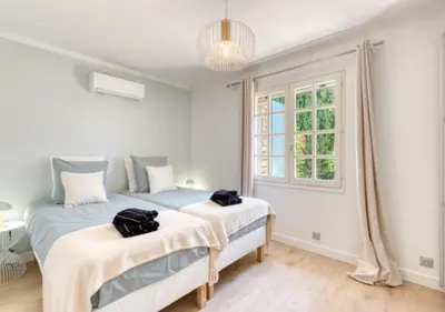 two beds in a white room with a window at Villa La Belle Vie in Gordes