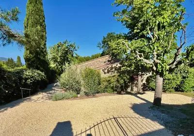 a house with a tree and a gravel driveway at Villa La Belle Vie in Gordes