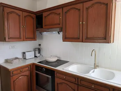 a kitchen with wooden cabinets and a sink at LE CHESTER - Maison de charme en Provence avec piscine près de L'Isle-sur-la-Sorgue in Velleron
