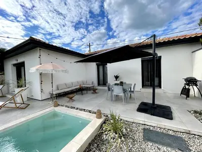 a patio with a pool and a table and an umbrella at Villa rosalie L'Isle-sur-la-Sorgue in LʼIsle-sur-la-Sorgue