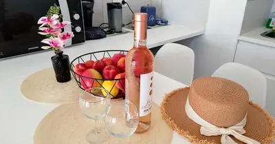 a bottle of wine and a basket of fruit on a table at Provence apartments in Aix-en-Provence