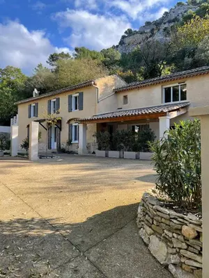 a patio with white furniture and a wooden roof at Fontaine de bonheur in Fontaine-de-Vaucluse