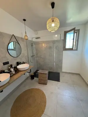 a large bathroom with two sinks and a shower at La Tobynette in LʼIsle-sur-la-Sorgue