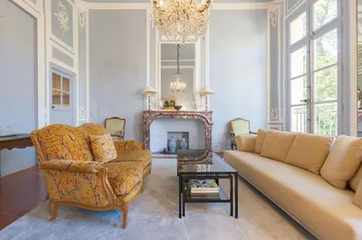 a living room with a couch and a chair and a chandelier at Cardinale 4 rooms in Aix-en-Provence