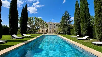 a pool in front of a house with trees at Château vert in Cavaillon